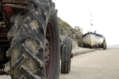 Tractor and fishing boat on the seafront at Overstrand, Norfolk, UK.の写真素材