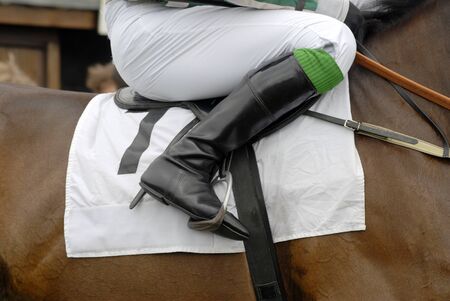 Jockey's boot in the stirrup on a racehorse.の写真素材