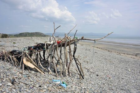 Beach art sculpture or shelter made from driftwood, rubbish and washed up flotsam on the shore Black Rock Sands beach near the Welsh village of Morfa Bychan, Gwynedd, Pothmadog, North Wales. UK.のeditorial素材