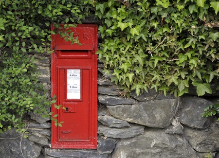 Victorian red post office mail box set into a stone wall.の写真素材