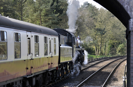Steam locomotive The North Norfolkman, standard class engine leaving Weybourne Railway Station, part of the North Norfolk Railway, also known as the poppy line steam heritage railway in Norfolk, UK.の写真素材