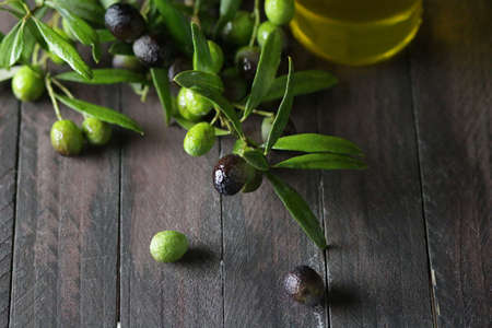 Fresh olives and olive oil on wooden tableの写真素材