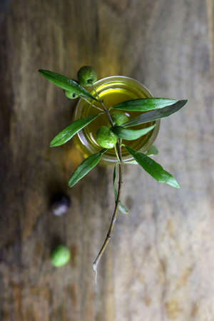 Fresh olives and olive oil on wooden table