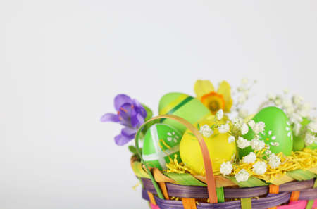 Easter eggs and flowers in basket isolatedの写真素材