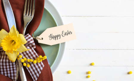 Easter table with cutlery on wooden table with tag