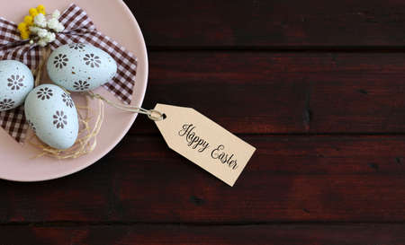 Easter decoration on wooden table with tag