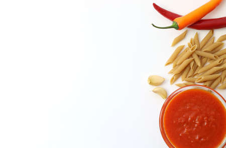 Italian tomato sauce with basil and whole wheat pasta on white backgroundの写真素材