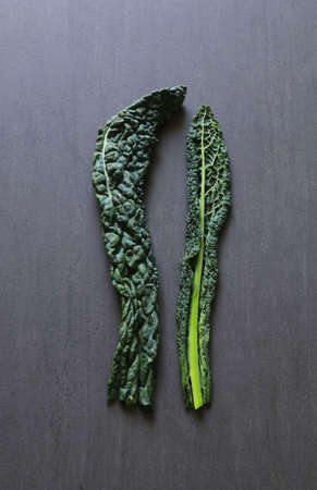 Italian cuisine. Black italian cabbage isolated on dark background. Top view