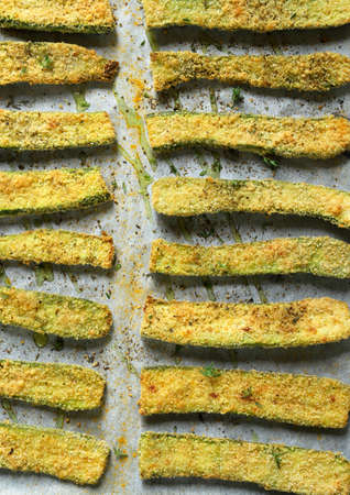 Homemade food concept. Top view of slices of gratin zucchini with bread crumbs and herbs