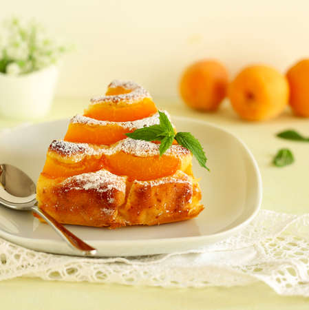 Vegetarian dessert. Close-up of sliced apricot pie on a white plate. Selective focus.の写真素材