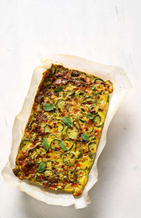 Food concept. Oven baked omelette with zucchini, leeks and cheese isolated on white background. Top viewの写真素材