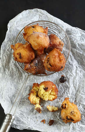Concept of italian food. Top view of homemade traditional carnival sweets: carnival italian fritters with sultanas on dark background.の写真素材