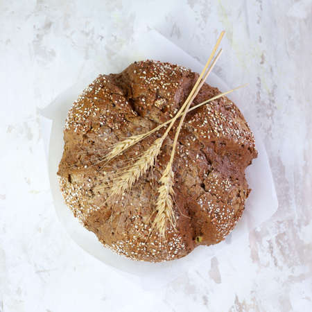 Rustic baked cereal bread with wheat ears, view from above on light background. Copy space.の写真素材