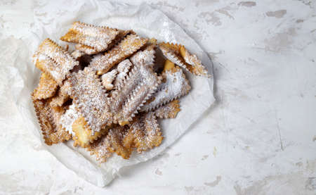Top view of homemade traditional carnival sweets: chat on white background. Copy space.