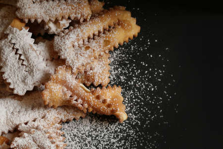 Top view of homemade traditional carnival sweets: chat on dark background. Copy space.