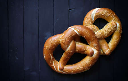 Concept of bavarian food. Traditional baked bavarian salted pretzels on dark background.の写真素材