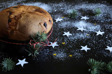 Christmas holiday.Traditional Italian Christmas Panettone cake with dried fruits on dark background. Closeup.の写真素材