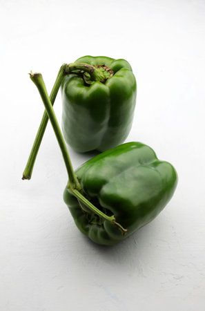 Two fresh green peppers isolated on white background. Top view.