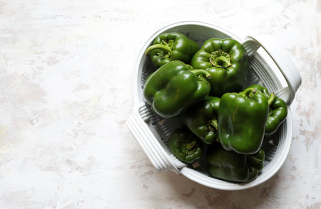 Fresh green peppers in a basket on white background. Copy space. Top view.の写真素材