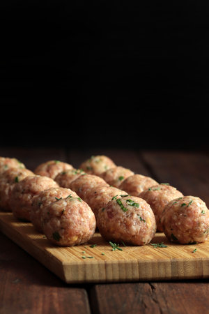 Fresh raw meat balls isolated on wooden table. Copy space.