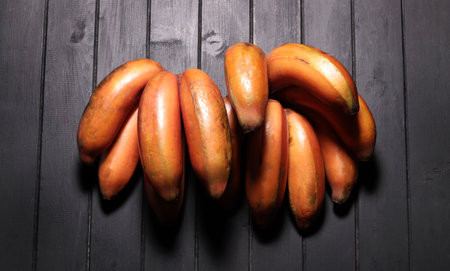 Fresh red banana isolated on dark background. View from above. 'Red Dacca'の写真素材