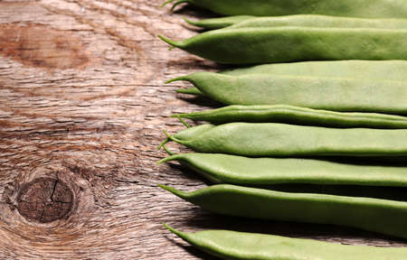 Green beans platters isolated on wooden background. Jackdaws. Top view, copy space.