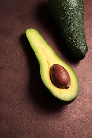 Fresh avocado on dark background. Vegetarian food concept. Top view.