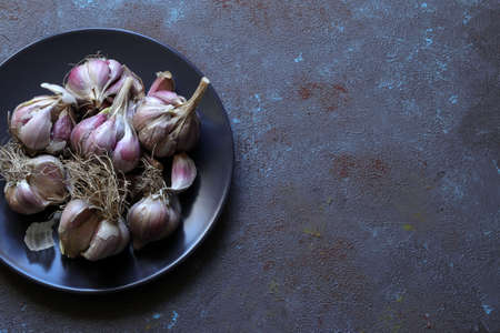 Closeup of garlic bulbs isolated on dark background.の写真素材
