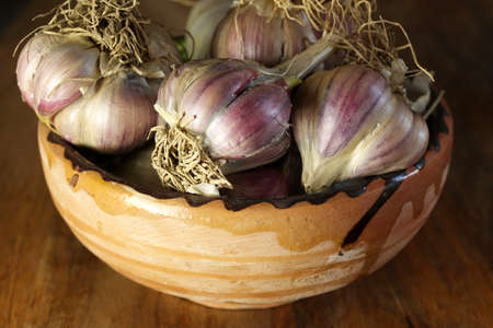 Closeup of garlic bulbs isolated on wooden table.の写真素材