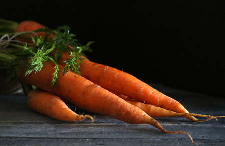 Bunch of fresh orange carrots on dark background.の写真素材