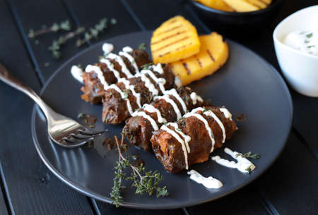 Traditional turkish dolma, sarma or dolmades. Dolmadakia or stuffed grapes leaves on dark background. Traditional mediterranean dish.の写真素材