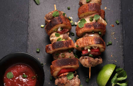 Grilled meat skewers isolated on dark background. Rustic style. Copy space. Directly above.