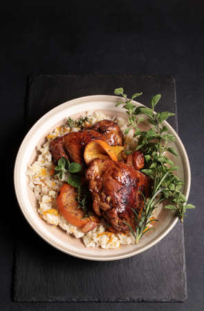 Roasted chicken with oranges and herbs in a pan on wooden background. Directly above.の写真素材