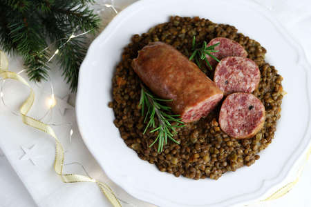 Cotechino with lentils served on a plate. Christmas decorations. Italian food.の写真素材