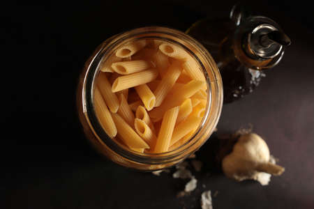 Raw Italian pasta with ingredients on dark background. Directly above.