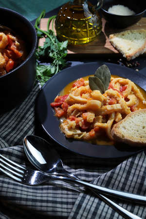 Italian food. Dish of typical beef tripe with tomato sauce with bread croutons in the plate on the...