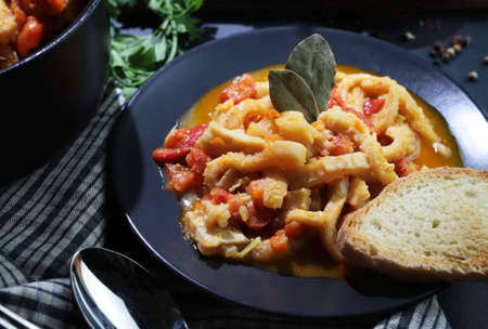 Italian food. Dish of typical beef tripe with tomato sauce with bread croutons in the plate on the...