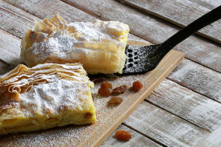 Homemade traditional Greek cuisine. Bougatsa, phyllo pastry filled with cream and sultanas,...