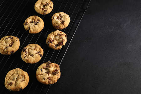 Chocolate chip cookies isolated on dark background. Directly above.