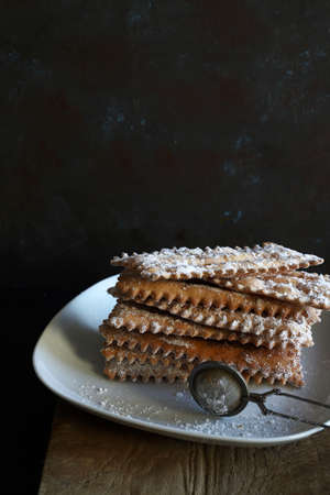 Homemade traditional Italian carnival sweets: chat on dark background. Copy space. Directly above.