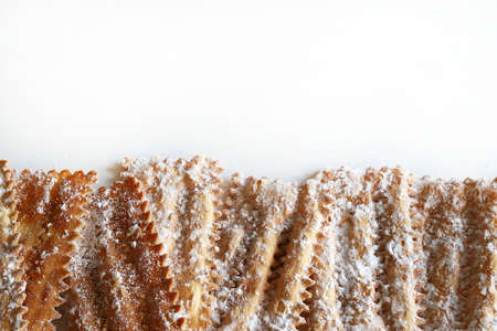 Homemade traditional Italian carnival sweets: chiacchiere on white background. Copy space. Directly above.の写真素材