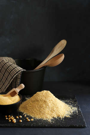 Cornmeal and corn kernels on a black background.