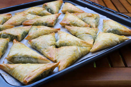 Greek food. Spanakopita, phyllo pastry triangle with spinach and feta cheese. Directly above.