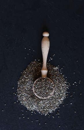 Concept of healthy food. Chia seeds in a black bowl isolated on dark background. Top view.の写真素材