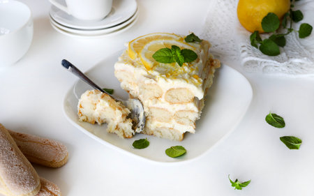 Italian lemon tiramisu. Lemon tiramisu with ladyfingers and mascarpone cream on a white table, fresh...