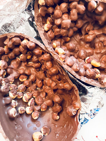 Chocolate Easter egg. Two halves of a chocolate Easter egg filled with hazelnuts cracked in pieces...