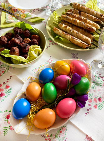Traditional Easter food. Easter table setting with Russian salad, colorful eggs, appetizer, meatballs. Family gathering concept. Holiday season. Directly above.の写真素材