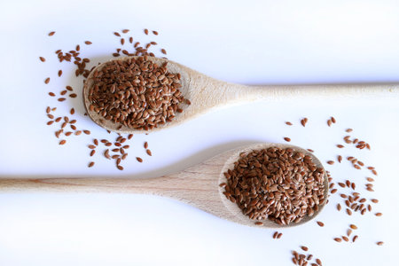 Flax seeds wooden spoon isolated on a white background. Flax seeds are rich in fiber, omega-3 fatty acids and lignans. Healthy food concept. Copy space.の写真素材