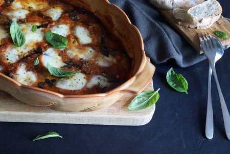 Baked aubergine parmesan. Dish based on aubergines, tomato sauce, fresh basil leaves, parmesan and mozzarella. Italian food. Directly above.の写真素材
