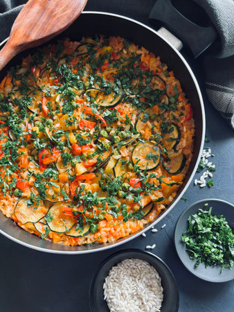 Close-up of traditional vegetable Paella served in pan. Spanish rice dish. Mediterranean diet....